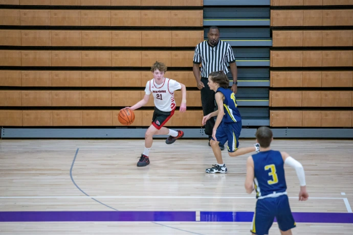 a group of young men playing a game of basketball